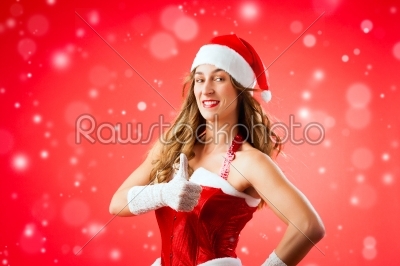 Attractive young woman in Santa Claus costume with thumbs up