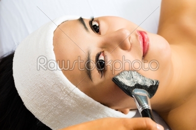 Cosmetics - Asian woman gets a facial mask