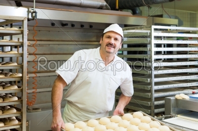 Male baker baking bread rolls