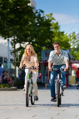 urban couple riding bike in free time in city