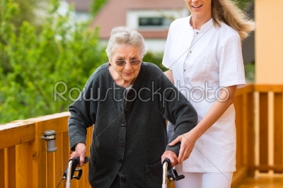 Young nurse and female senior with walking frame