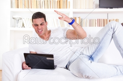 angry man having troubles with laptop computer