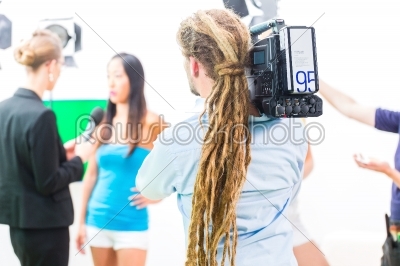 Cameraman shooting with camera on film set