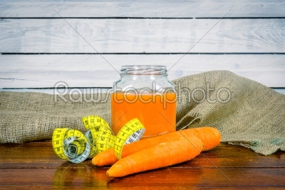 Carrot juice with measure tape on a table