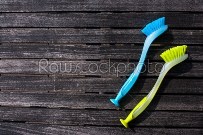 Colorful cleaning brushes on a wooden table