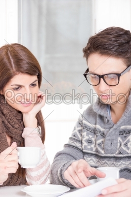 couple drinking coffee and reading newspapers