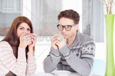 couple holding cups of coffee in hands drinking it at home