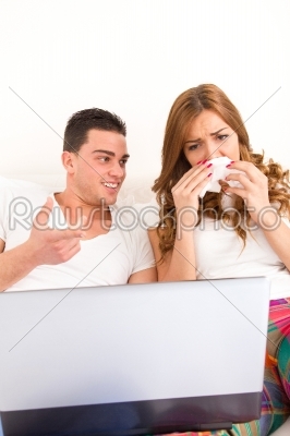 couple watching sad movie in bed on laptop computer