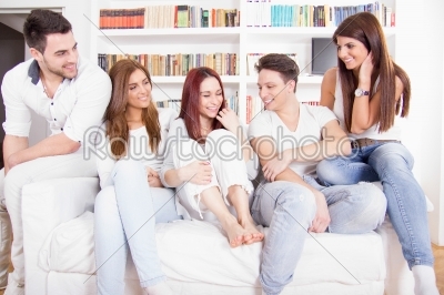 friends having conversation on sofa at home