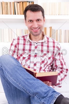 handsome man relaxing at home on a sofa in the living room readi