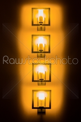 Set of yellow wall lamps in the darkness