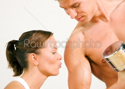Sexy couple with dumbbells in gym