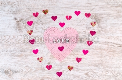 Word Love with paper Hearts shaped Valentines Day on white wooden background